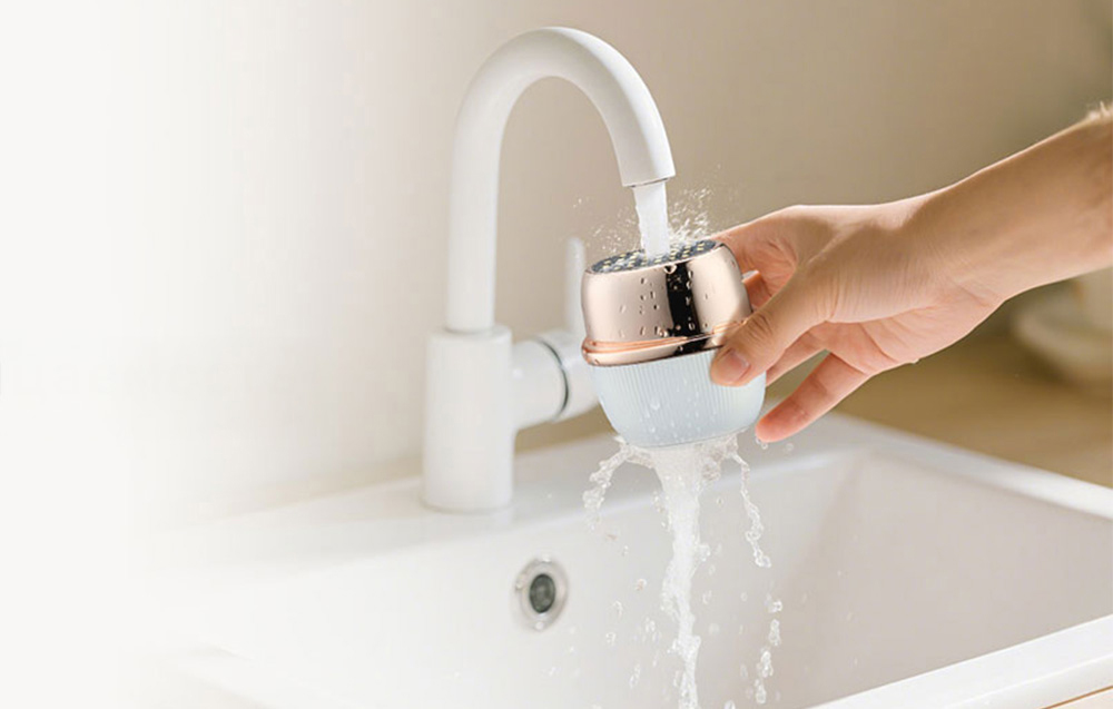 Appareil de massage facial nettoyé sous l'eau courante