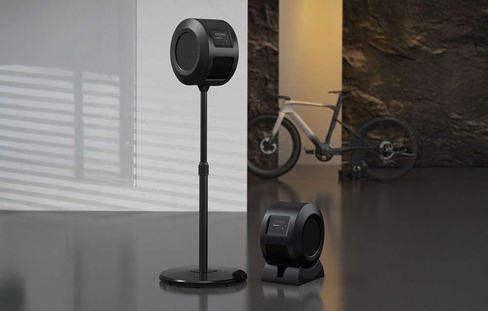 Deux ventilateurs Cycplus noirs sur un support et une base dans la pièce avec le vélo