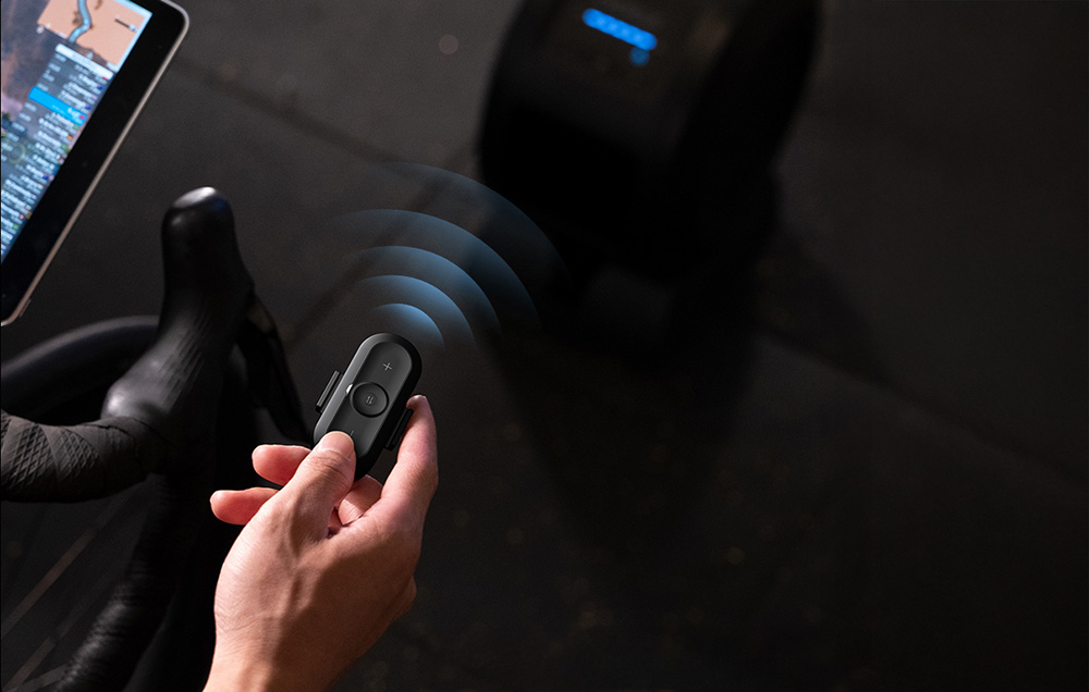 Main tenant la télécommande du ventilateur contre le guidon du vélo