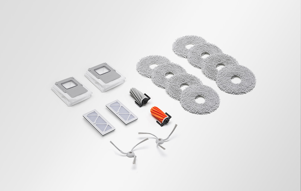 Lingettes de nettoyage, brosses en caoutchouc, brosses latérales, filtres et sacs à poussière disposés sur un fond clair