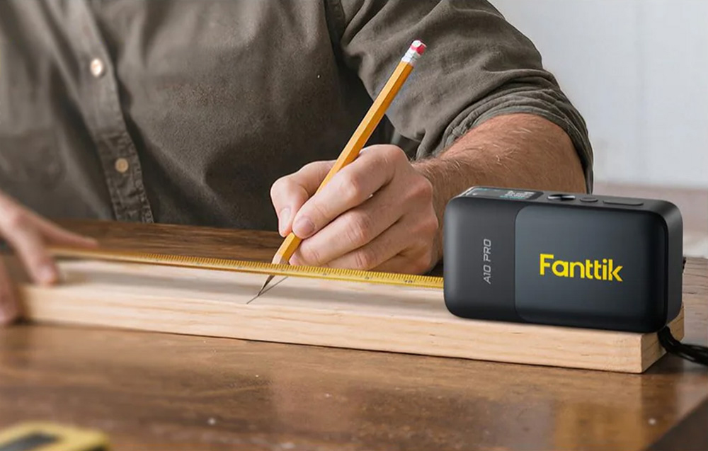 Homme mesurant une planche avec un mètre laser 2-en-1