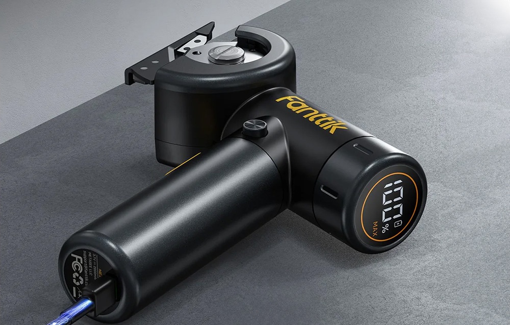 Une découpeuse électrique Fanttik noire repose sur un plan de travail gris connectée à un câble USB.