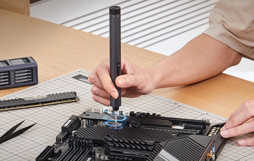 Un homme répare un appareil avec un tournevis de précision.