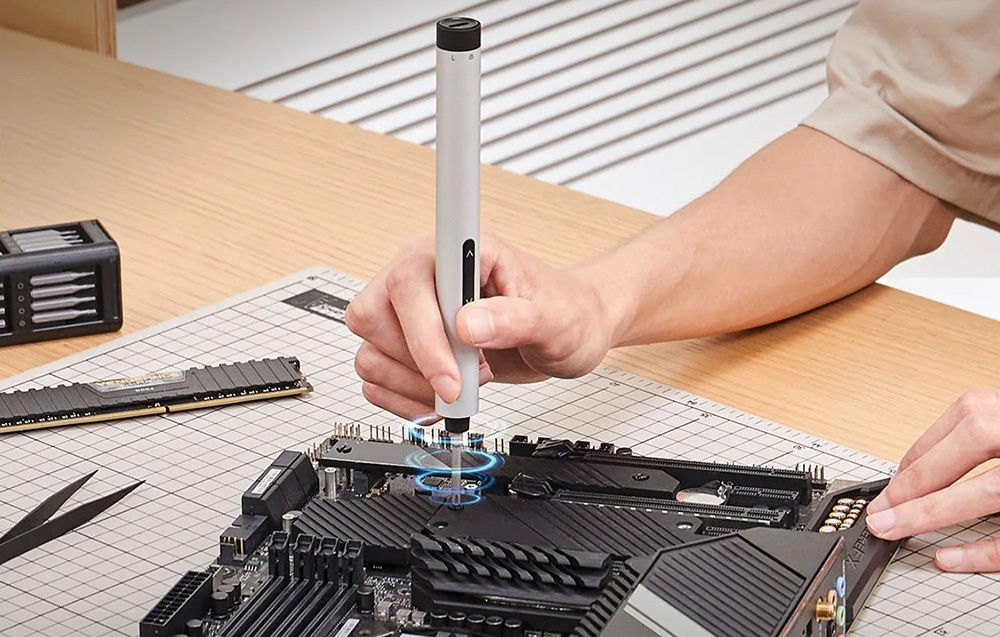 Un homme répare un appareil avec un tournevis de précision.