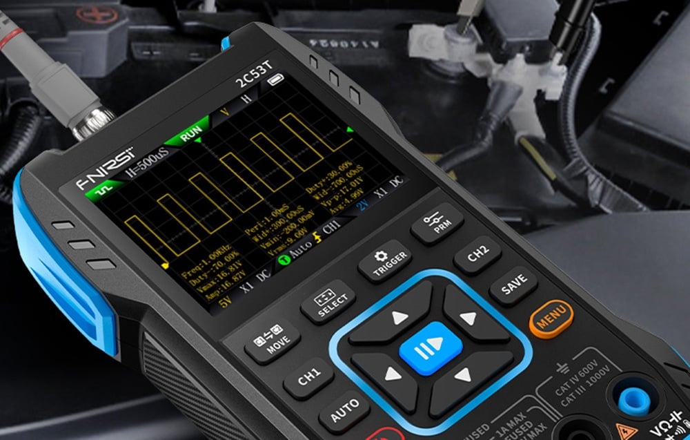 Appareil de mesure avec graphique de forme d'onde sur l'écran, connecté par un câble, compartiment moteur visible en arrière-plan.