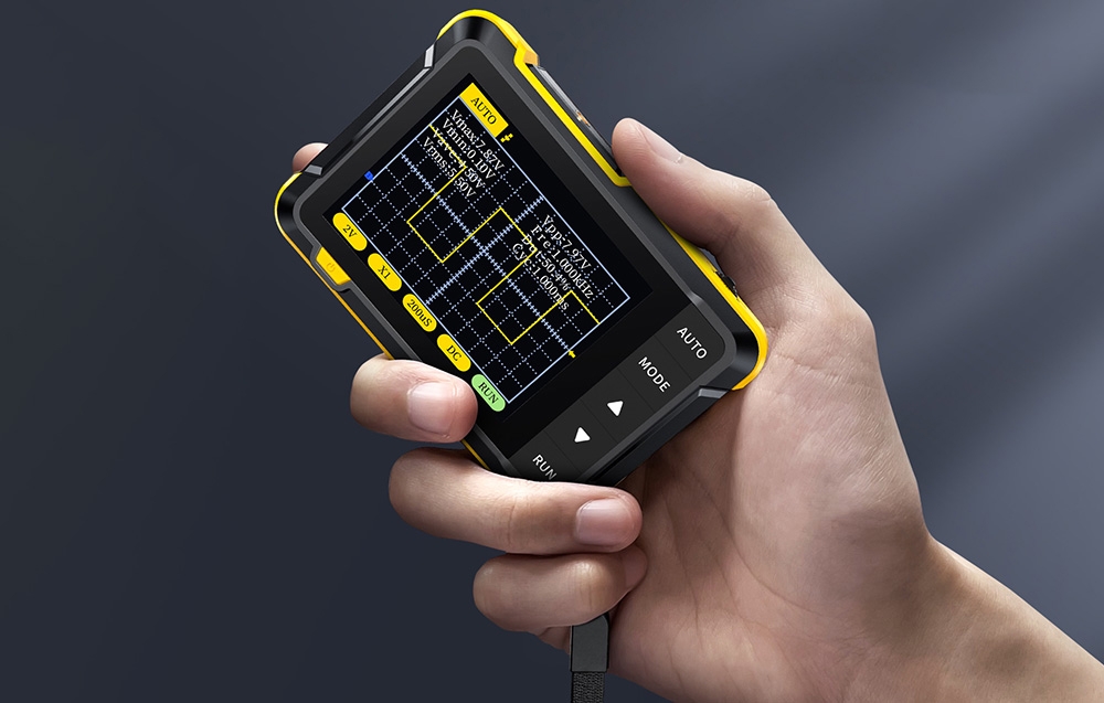 Ręka trzyma przyrząd pomiarowy z kolorowym ekranem pokazującym wykres fal i parametry napięcia.