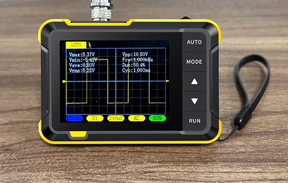 Przyrząd pomiarowy z ekranem wykresu fal leży na drewnianym blacie z przymocowanym paskiem na nadgarstek.