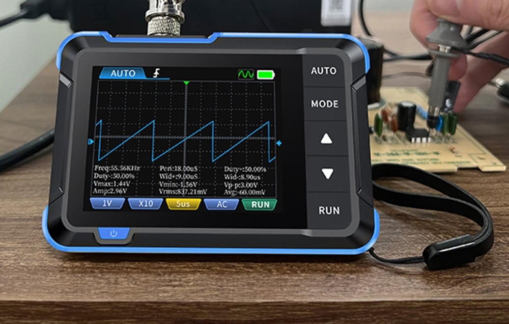 Oscilloscope FNIRSI DSO153 sur une table en bois, affichant des données