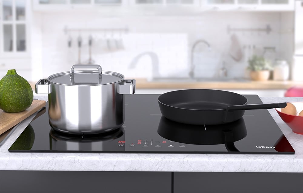 Plaque à induction IsEasy avec bouilloire en inox et poêle noire dans une cuisine lumineuse