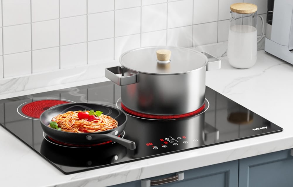 Plaque en céramique avec poêle à spaghetti et casserole en acier inoxydable dans une cuisine blanche