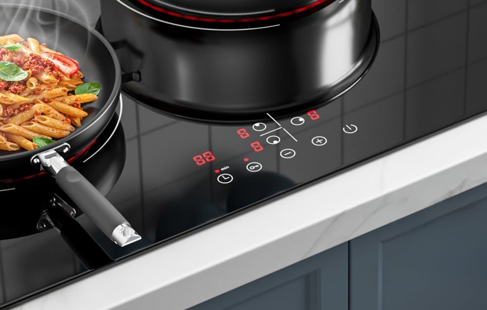 Gros plan du panneau de contrôle d'une plaque à induction avec une poêle de nouilles et une casserole noire