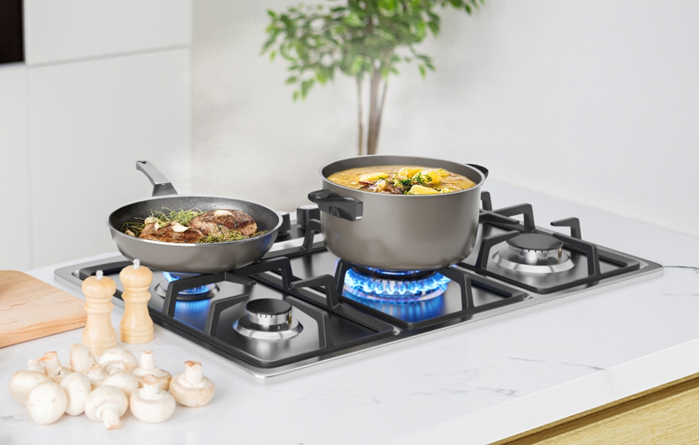 Plaque de cuisson avec poêle et casserole sur flammes bleues