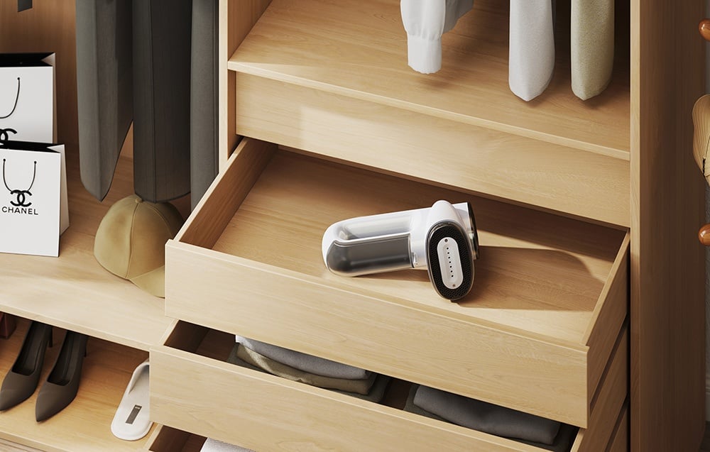 Le défroisseur blanc repose dans un tiroir en bois ouvert