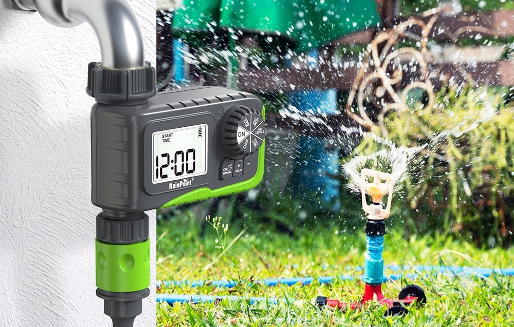 Minuteur d'arrosage installé sur un robinet à côté d'un arroseur de jardin