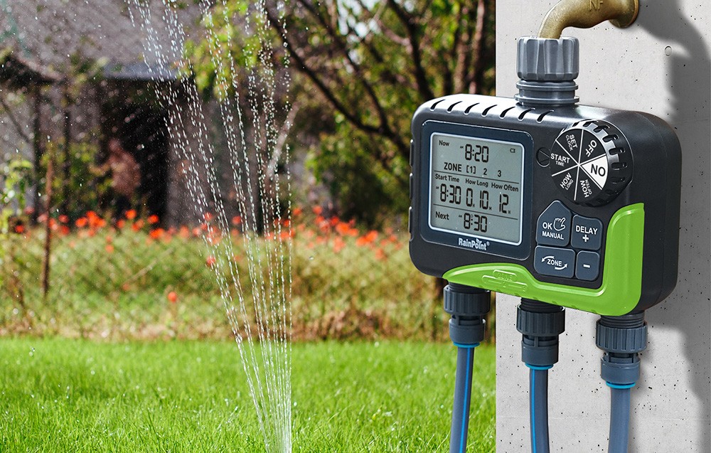 Contrôleur RainPoint monté sur un poteau en béton arrosant la pelouse avec un jet d'eau