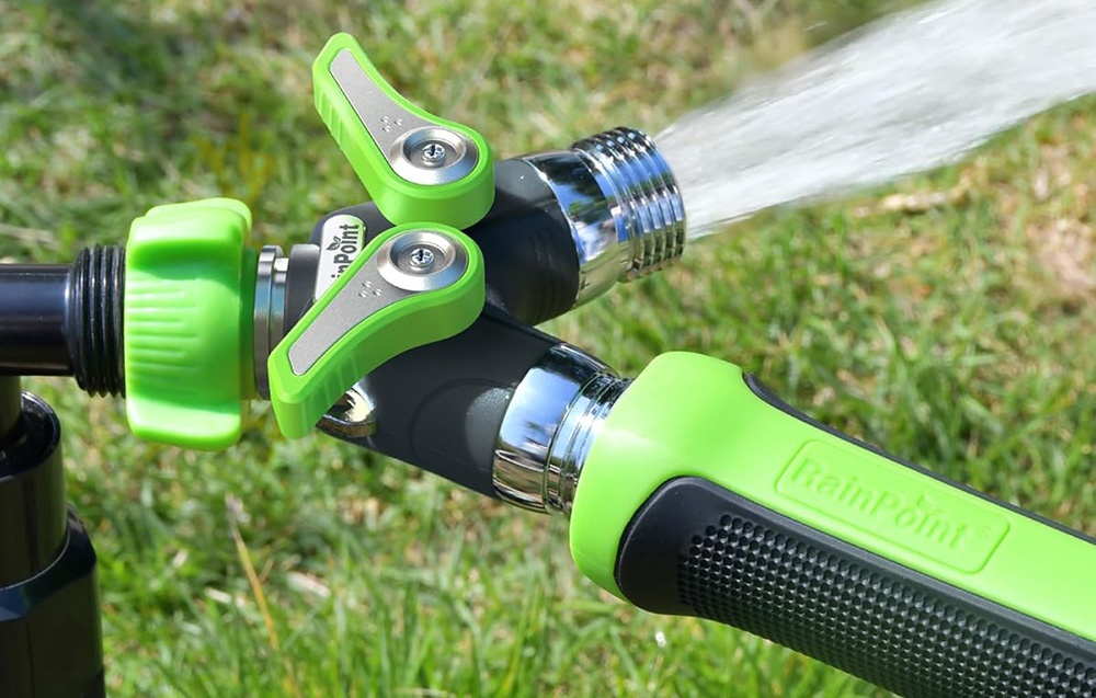 Répartiteur de tuyau de jardin à deux voies avec vannes vertes et tuyau connecté d'où l'eau s'écoule