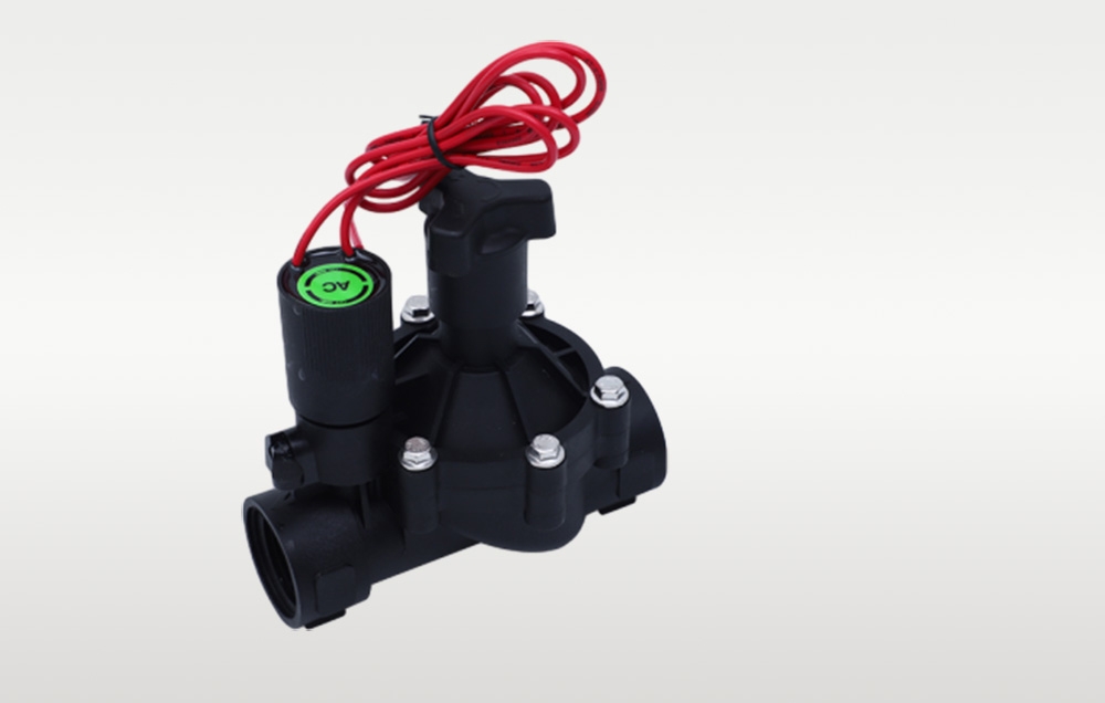 Petite vanne électromagnétique d'irrigation noire avec fil rouge vue en angle par le dessus