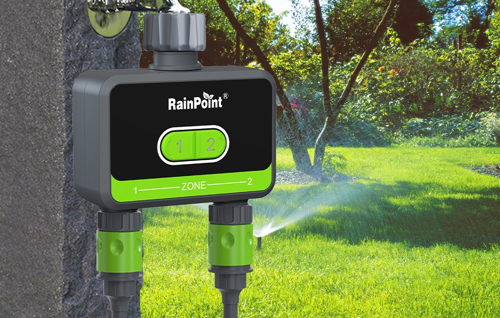 Contrôleur d'irrigation RainPoint en couleur verte, derrière se trouve le jardin.