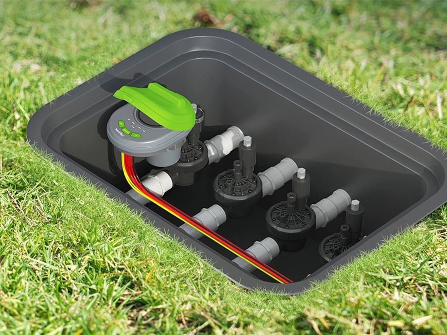 Contrôleur RainPoint monté dans une boîte de jardin, connecté à des vannes et des fils.