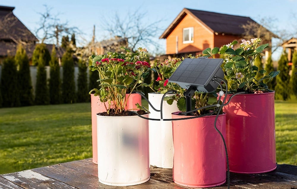 Kit solaire RainPoint monté dans un pot rose, à côté se trouvent des pots similaires dans des teintes claires.