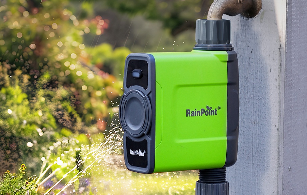 Contrôleur d'irrigation RainPoint installé près d'un robinet, à côté d'un arroseur de jardin