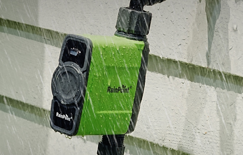 Contrôleur d'irrigation sur le mur d'une maison pendant une forte pluie