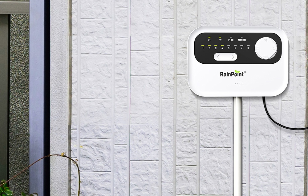Contrôleur d'arrosage RainPoint monté sur un mur blanc.